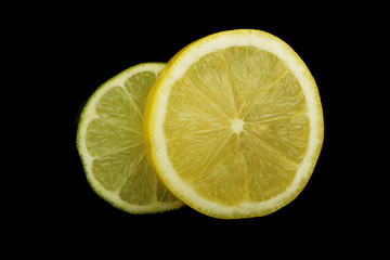 lime and lemon slices on black background isolated