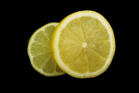 lime and lemon slices on black background isolated