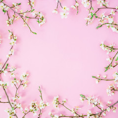 Plakat Floral frame made of spring white flowers on pink background. Flat lay, top view. Spring time background.