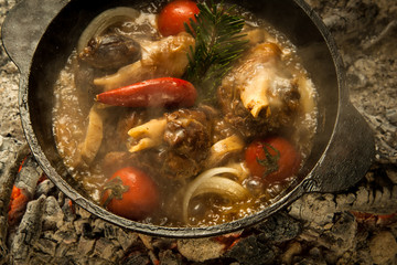 meat soup with vegetables prepared on burning coals. the dish is cooked and smoked on charcoal