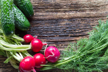 fresh vegetables, radishes, dill, cucumber, onion, cabbage on a wooden background