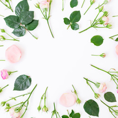 Obraz na płótnie Canvas Round frame of pink roses, leaves and buds on white background. Flat lay, top view.