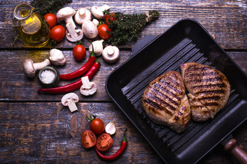  Beef Steak, salt, pepper, garlic, rosemary, mushrooms, olive oil  on the black board, background.