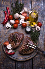  Beef Steak, salt, pepper, garlic, rosemary, mushrooms, olive oil  on the black board, background.