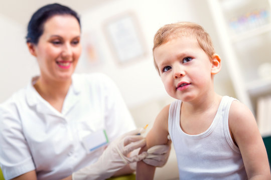 Female pediatrician makes vaccination to small boy