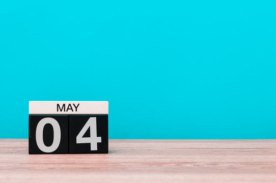 May 4th. Day 4 of month, calendar on turquoise background. Spring time, empty space for text