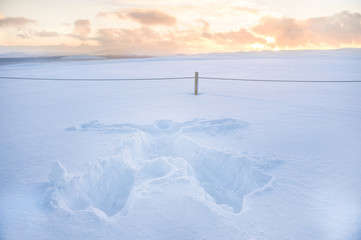 Snow print of human full body shaped on the thick fresh snow with sunset