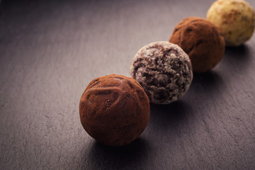 Chocolate truffle,Truffle chocolate candies with cocoa powder.Chocolate candies collection.Assorted chocolate truffles with cocoa powder, coconut and chopped hazelnuts on a dessert plate.