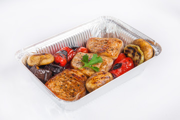 Close up Healthy restaurant food delivery in foil box. Grilled meat steak and vegetables. Meals take away, selective focus. Isolated on the white background.
