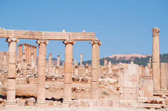 Jerash, Giordania, 04/10/2013: le colonne ioniche del Foro ovale e sullo sfondo le corinzie del Tempio di Artemide nell'antica Gerasa, uno dei siti di architettura romana meglio conservati al mondo