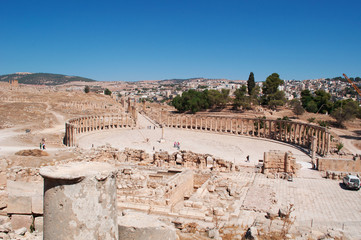 Fototapeta na wymiar Giordania, 04/10/2013: lo skyline della moderna Jerash con vista del Foro ovale e del Cardo Massimo dell'antica Gerasa, uno dei siti di architettura romana meglio conservati al mondo