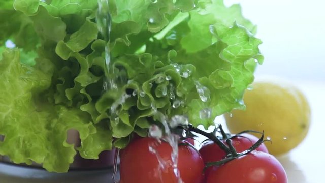 Fresh lettuce salad falls under water with a splash. Super slow motion