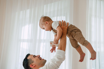 Portrait of handsome Father and son 1 year old having fun happy and smiling hugging in studio at the day time. Concept of friendly family.