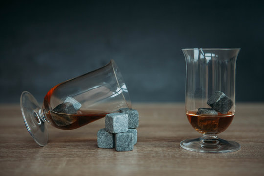 Stones for cooling whiskey and glases tulup on dark wooden background