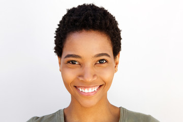 Close up beautiful young black woman smiling against white wall