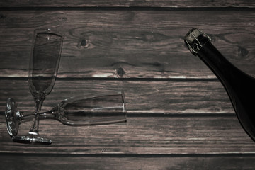 Bottle of sparkling wine and glasses on wooden boards