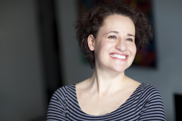 Mature Woman Smiling. At Home. Looking up.