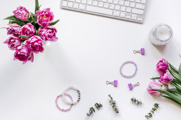 Flowers on trendy desk in office white background top view mock up