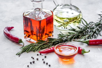 oil in carafe with spices, olives and chili on stone background