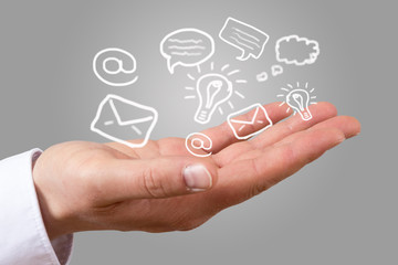 Hand offen mit fliegenden Symbolen der Kommunikation