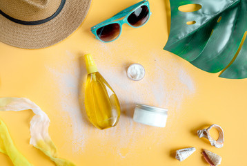 Summer cosmetic set with protection cream on orange background top view