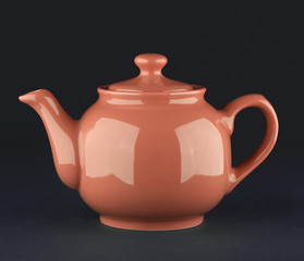 Brown ceramic teapot isolated on black background