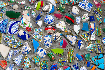 Wall with broken ceramic plates colored fragments 