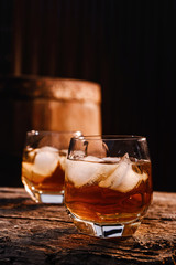 Glass of whiskey on wooden background close up