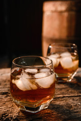 Glass of whiskey on wooden background close up