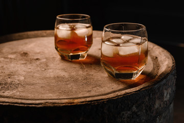 Glass of whiskey on wooden background close up