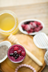 Raspberries, blueberries chia smoothie with touch of honey, served in a tall glass