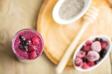 Raspberries, blueberries chia smoothie with touch of honey, served in a tall glass