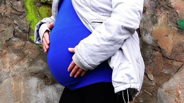 a girl in the position of stroking the belly with her hands communicating with the embryo
