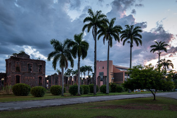 Fototapeta na wymiar Ruins of Sugar Mill of Colonial Times in Brazil, with Palm Trees by Sunset