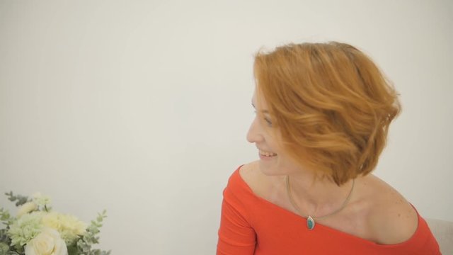 An attractive caucasian adult woman smiles, talks and laughs at the camera