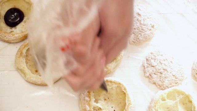 Woman's hands adding the chokolate to the eclair