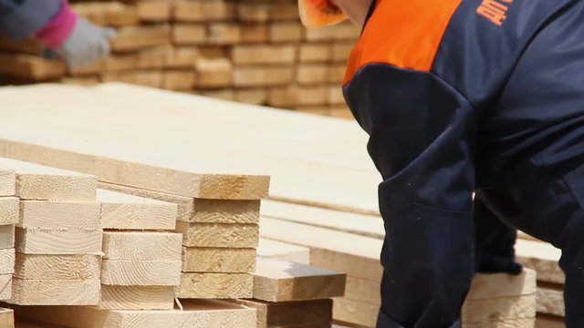 Sawmill. The worker puts the boards.