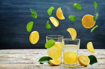 Lemonade with flying lemon, mint and ice