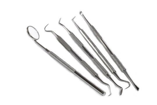 Dentist tools laid out against white background