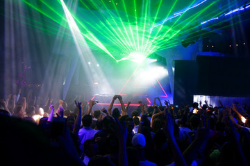 Night club dj party people enjoy of music dancing sound with colorful light with Smoke Machine and lights show. Hands up in the earth.