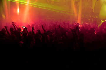 Fototapeta na wymiar Night club dj party people enjoy of music dancing sound with colorful light with Smoke Machine and lights show. Hands up in the earth.