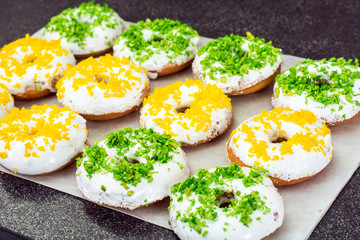 Small donuts with white frosting and colored sprinkles