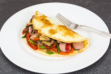 Breakfast omelet with vegetables and sausages