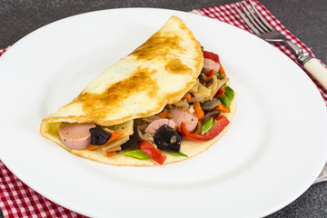 Breakfast omelet with vegetables and sausages