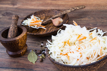 Salad from sauerkraut with carrots in wooden bowl