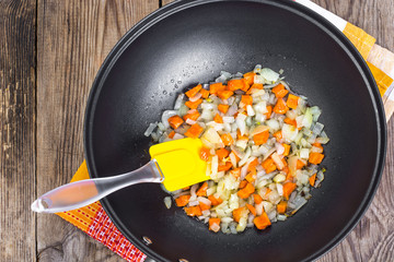 Fried onions and carrots in the pan. View from the top