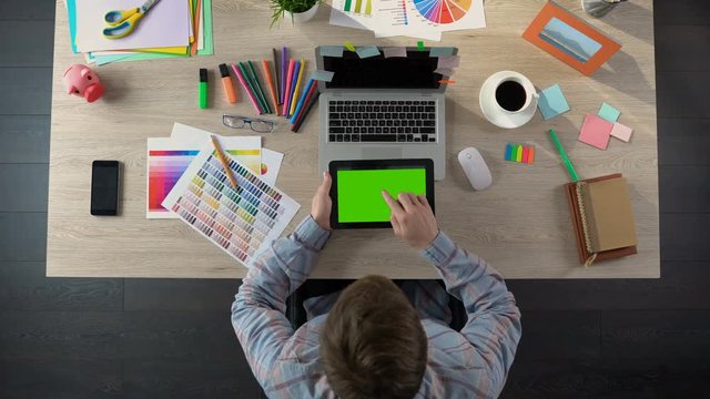 Designer checking mail on tablet with green screen waiting for letter with order