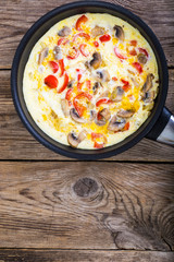 Frittata with mushrooms and peppers in frying pan