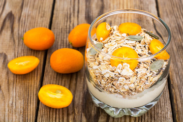Healthy breakfast, oatmeal with kumquats, granola, yoghurt, chia