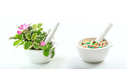 Alternative medicine concept - Herbs and pills in mortars on white background